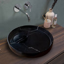Natural Stone Toros Black Marble Above Vanity Designer Bathroom Sink Polished (D)17.5" (H)6" installed above wooden vanity chrome wall mount faucet and vase toothbrushes and lotion on the vanity green wall