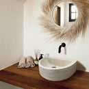 Troia Light Travertine Half Round Wall-mount Bathroom Sink (W)10" (L)16" (H)6" installed bathroom above wooden vanity and brown hand towels room scent wide view