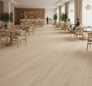 Modern restaurant interior with wooden flooring, tables, and chairs.