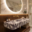 Luxurious bathroom with marble vanity, towels, and decorative items.