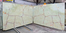 Green onyx slabs with red vein patterns in a warehouse setting