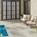 Outdoor patio with wicker chairs, cushions, and a pool area.