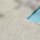Close-up of beige tiles with a pool edge in the corner