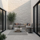 Modern outdoor patio with a sectional sofa, coffee table, and decorative elements.