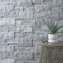 Gray stone wall with a small table and plant