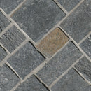 Close-up of gray stone tiles arranged in a herringbone pattern