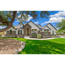 Stylish two-story house with a well-maintained lawn and trees under a blue sky.
