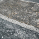 Close-up of a stone surface with a visible joint between two slabs.