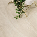 Beige tiles with a gold chair and green plant in the corner