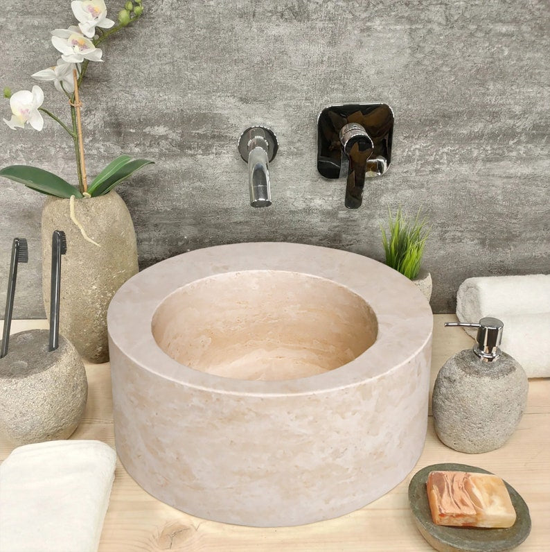 Natural Stone Light Beige Travertine Misaligned Round Above Counter Bathroom Sink installed bathroom above counter chrome wall-mount faucets soap and white towels