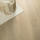 Close-up of a wooden floor with a gold decorative basket and white rug.