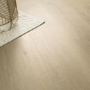 Close-up of a light wood floor with a rug and basket in the corner.