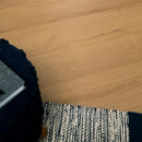 Close-up of a textured black and white rug on a wooden floor