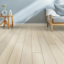 Wooden flooring with a minimalistic room setup including a table and bed.