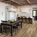 Modern kitchen with wooden dining table and chairs, island, and pendant lights.