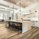 Modern kitchen with white island, wooden floor, and pendant lights.