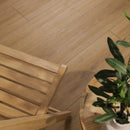 Wooden chair and table with a plant on a wooden floor