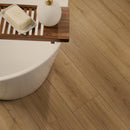 Wooden bath caddy with soap and white bottle next to a bathtub on a wooden floor.