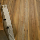 Wooden flooring with a white rug and wooden bench in the corner.