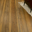 Wooden floor with a section of a rug and a piece of furniture partially visible.
