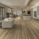 Modern living room and kitchen with wooden flooring, white furniture, and large windows.