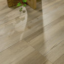 Close-up of wooden flooring with a plant in the corner