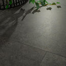 Dark gray tiles on a floor with a plant casting shadows