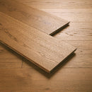 Close-up of a wooden floor with a plank partially laid down
