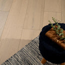 Wooden floor with a rug and plant