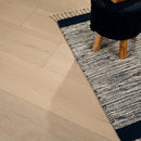 Patterned rug on a wooden floor with a wooden stool