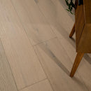 Close-up of a wooden floor with a piece of furniture partially visible.