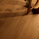 Close-up of a wooden floor with a chair leg partially visible