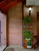 manufactured stone brick veneer slimfix red handmade B05RE 102266 installed on sunroom shelves plants wide view
