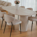 Troia Light Travertine Oval Dining Table with Fluted Round Legs (W)40" (L)75" (H)30" living room view beige color chairs wooden floors closeup view